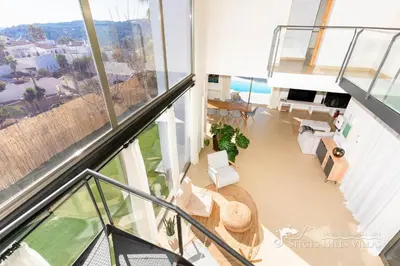 a white living room with a white couch and a tv at Designer Villa Elodie with private pool and space in Olivella