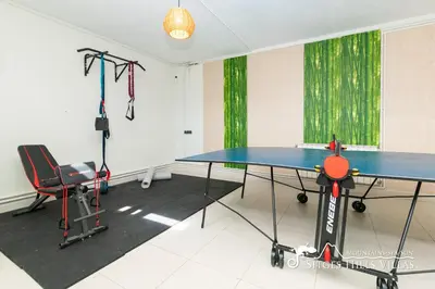 a ping pong table in a room with green curtains at Designer Villa Elodie with private pool and space in Olivella
