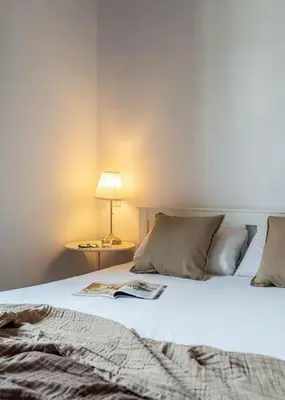 a bedroom with a bed with a book on it at Canela Homes BARCELONA LIGHT in Barcelona