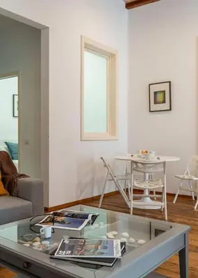 a living room with a glass table and a table and chairs at Canela Homes BARCELONA LIGHT in Barcelona