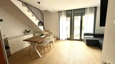 a kitchen and living room with a table and a couch at Dúplex 2 hab con terraza by Prestigi in Terrassa