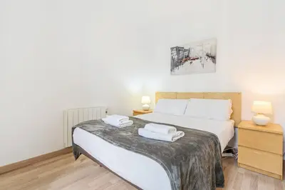 a bedroom with a bed with two towels on it at Avenida Gaudí View 2-Min to Sagrada in Barcelona