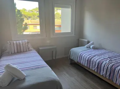 two beds in a room with two windows at Apartment of 100m2 with sea views in Sant Vicenç de Montalt