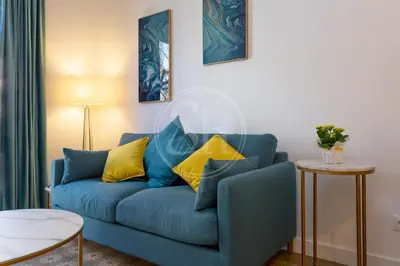 a blue couch with yellow pillows in a living room at Apartamento cerca de Sagrada Familia in Barcelona