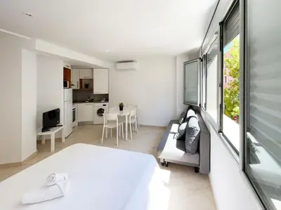 a room with a bed and a couch and a kitchen at M2 Apartament cèntric in Terrassa