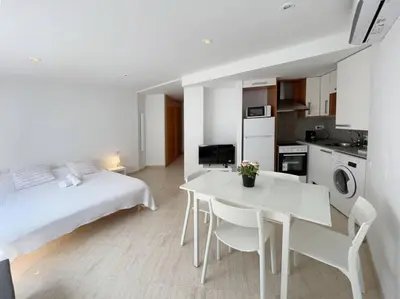 a white room with a bed and a white table and chairs at M2 Apartament cèntric in Terrassa