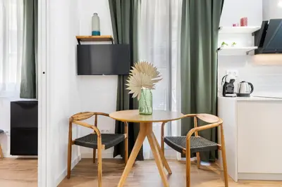 a table with two chairs and a vase with a flower at Lodging Apartments Almirall Beach 31 in Barcelona