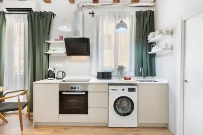 a kitchen with a washing machine and a sink at Lodging Apartments Almirall Beach 31 in Barcelona