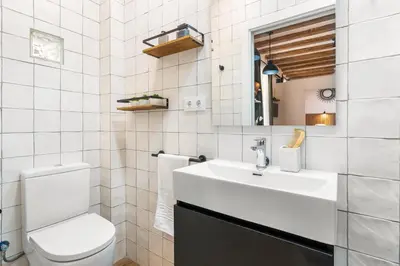 a white bathroom with a sink and a toilet at Lodging Apartments Almirall Beach 21 in Barcelona