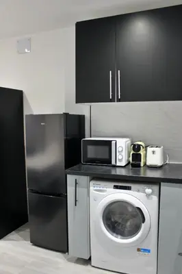a kitchen with a washing machine and a microwave at Work Stay in Gavà