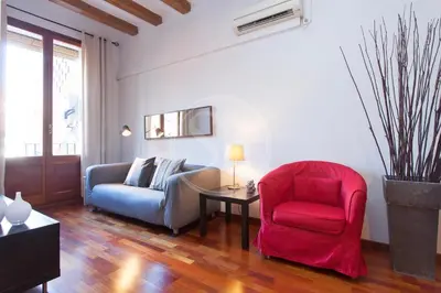 a living room with a red chair and a couch at Tranquilo y luminoso apartamento en el Eixample in Barcelona