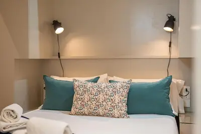 two lights on top of a bed with pillows at Stay U-nique Apartment Boters in Barcelona