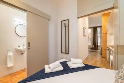 a bedroom with a bed and a bathroom with a sink at Stay U-nique Apartment Boters in Barcelona
