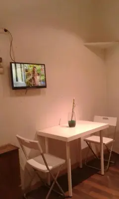 a white table and chairs with a tv on the wall at 029 Apartament 2-2 in Barcelona