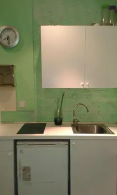 a kitchen with a sink and a clock on the wall at 029 Apartament 2-2 in Barcelona