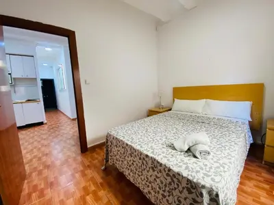 a bedroom with a bed with a white comforter at 030 apartameto 4-1 in Barcelona