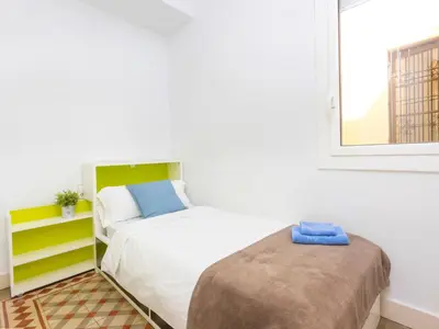 a small bedroom with a bed and a window at Apartment Eix-Dret-Roger de LLuria-Valencia by Interhome in Barcelona