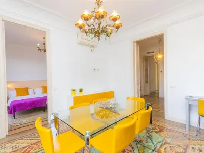 a dining room with a glass table and yellow chairs at Apartment Eix-Dret-Roger de LLuria-Valencia by Interhome in Barcelona