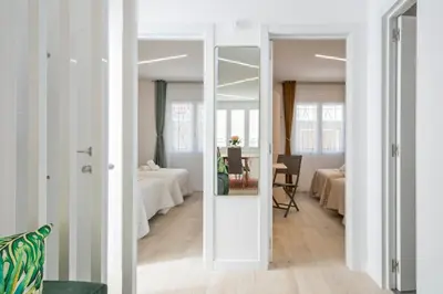 a living room with a mirror and a bedroom at Boutique Plaza Catalonia Suites Cornellá in Cornellà de Llobregat