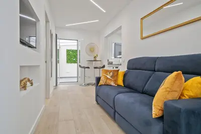 a living room with a blue couch with yellow pillows at Boutique Plaza Catalonia Suites Cornellá in Cornellà de Llobregat