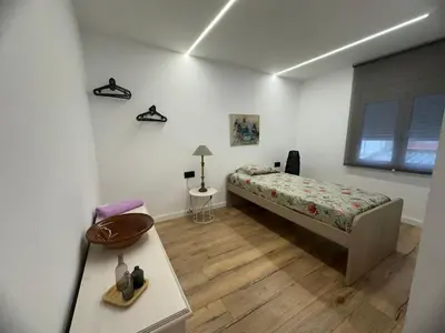 a bedroom with a bed and a table and a window at Vidanova 2 in Vilanova i la Geltrú
