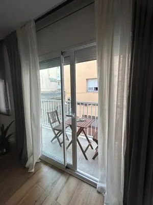a sliding glass door with a table and a balcony at Vidanova 2 in Vilanova i la Geltrú