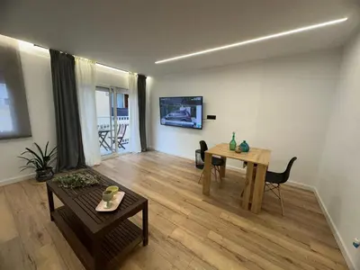 a living room with a table and a dining room at Vidanova 2 in Vilanova i la Geltrú