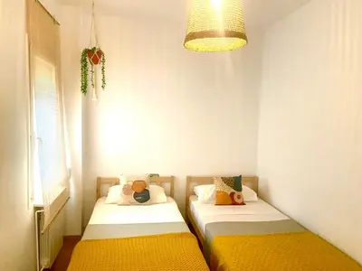 two beds in a small room with a lamp at Tucan tropical in Sabadell