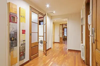a hallway with wooden floors and a hallway with doors at Alcam Sombrerers in Barcelona