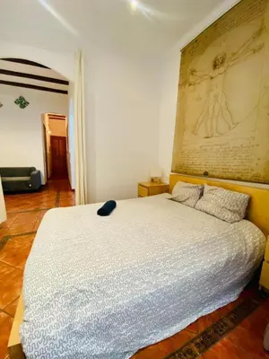 a bedroom with a white bed with a painting on the wall at 022 Center Barca 1,1 in Barcelona