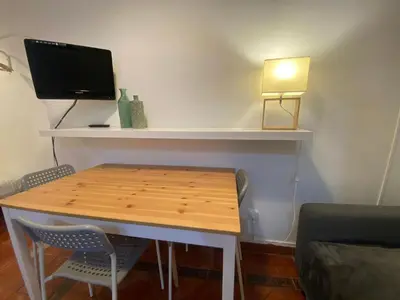 a room with a table and a desk with a television at 022 Center Barca 1,1 in Barcelona