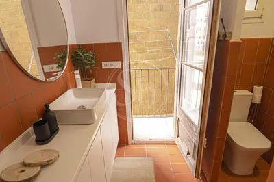 a bathroom with a sink and a toilet and a mirror at Maravilloso apartamento en Poble Sec in Barcelona
