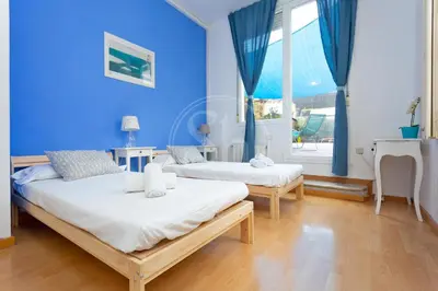 two beds in a room with blue walls at Apartamento con Terraza en Poble Sec in Barcelona
