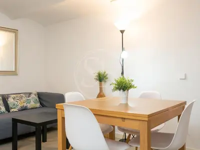 a kitchen and living room with a table and a couch at Apartamento en Villarroel in Barcelona