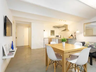 a dining room and living room with a table and chairs at Apartamento en Villarroel in Barcelona