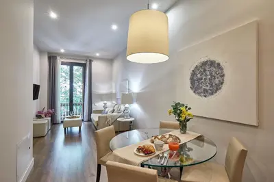 a dining room and living room with a glass table at BBarcelona Rogent Flats in Barcelona