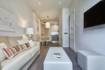 a living room with a white couch and a table at BBarcelona Rogent Flats in Barcelona