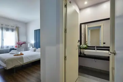 a bathroom with a bed and a sink in a room at BBarcelona Rogent Flats in Barcelona