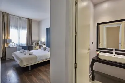 a hotel room with a bed and a sink at BBarcelona Rogent Flats in Barcelona
