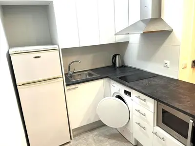 a white kitchen with a sink and a dishwasher at Apartamento 1 habitación cerca Sants-Estación in Barcelona