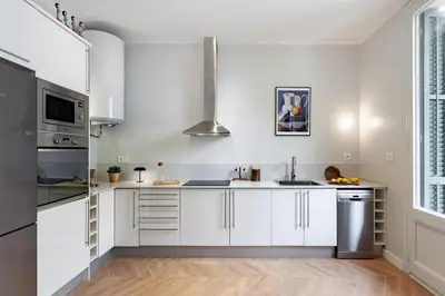 a kitchen with white cabinets and stainless steel appliances at Click&Flat Gaudi Dream II in Barcelona