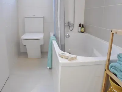a white bathroom with a tub and a toilet at Casa familiar luminosa con piscina, cerca de la playa y parques, ideal para 6 personas en Cubelles - ES-332-5 in Cubelles
