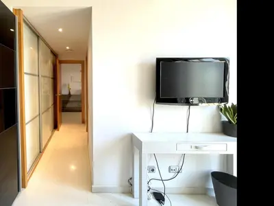 a living room with a tv on a white table at Casa espaciosa con piscina, aire acondicionado y jardín cerca de la playa de Vilanova - ES-332-9 in Sant Pere de Ribes