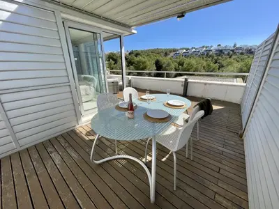 a patio with a table and chairs on a deck at Casa espaciosa con piscina, aire acondicionado y jardín cerca de la playa de Vilanova - ES-332-9 in Sant Pere de Ribes