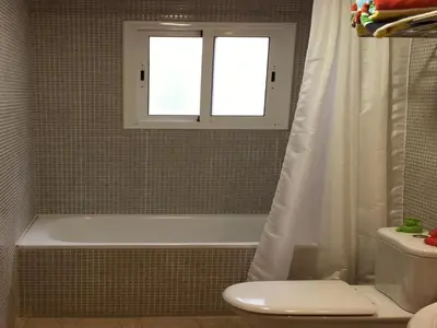 a bathroom with a tub and a toilet and a window at Ático Increíble con Terraza Privada en el Centro de Vilanova i la Geltrú - ES-332-7 in Vilanova i la Geltrú