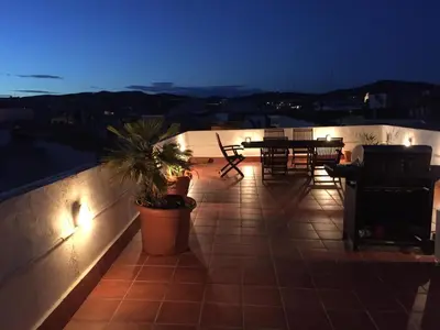 a patio with a table and chairs and lights at Ático Increíble con Terraza Privada en el Centro de Vilanova i la Geltrú - ES-332-7 in Vilanova i la Geltrú