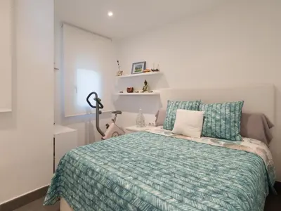 a bedroom with a bed with a green comforter and pillows at Apartamento cómodo frente al mar con acceso directo a la playa - ES-332-6 in Vilanova i la Geltrú