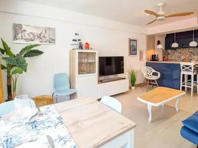 a living room with a table and a tv at Balcis Apartment by Hello Homes Sitges in Sitges