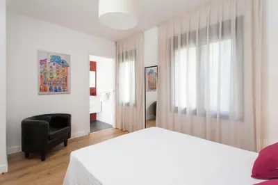 a bedroom with a bed and a chair and a window at Key San Pau House Terrace - Barcelona in Barcelona