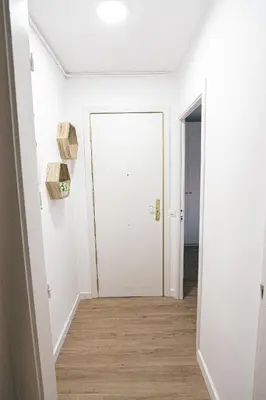 an empty hallway with a white door and wood floors at Cotonat in El Arrabal